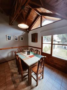a dining room with a wooden table and chairs at Casa Arrayanes Tempo in Esquel