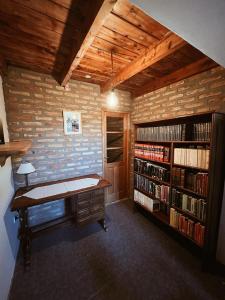 a room with a desk and a book shelf with books at Casa Arrayanes Tempo in Esquel