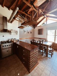 a kitchen with a stove and a table with chairs at Casa Arrayanes Tempo in Esquel