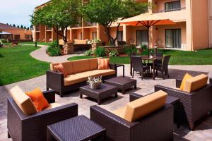 a patio with chairs and tables and an umbrella at Courtyard by Marriott Minneapolis-St. Paul Airport in Mendota Heights