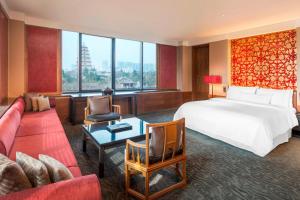 西安市にあるThe Westin Xi'an - Enjoy 2 Free bottles of beerのベッドと大きな窓があるホテルの部屋