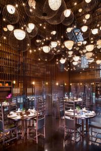 a dining room with tables and chairs and chandeliers at The Westin Xi'an in Xi'an