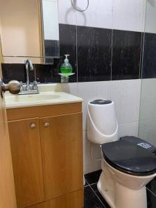 a bathroom with a toilet and a sink at Acogedor Apartamento Urbanización Tricentenario in Medellín