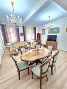 ein Wohnzimmer mit einem Holztisch und Stühlen in der Unterkunft Апартаменти Москва in Dobritsch
