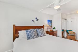 a bedroom with a white bed and a ceiling fan at Keawakapu 208 in Wailea
