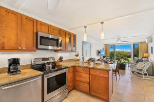 a kitchen with stainless steel appliances and a dining room at Keawakapu 208 in Wailea