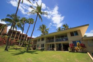 an exterior view of a building with palm trees at Keawakapu 208 in Wailea