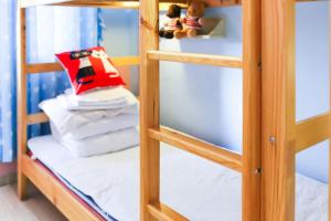 a bunk bed with pillows and a red bag on a shelf at Changsha Fuxiangyuan International Hostel in Changsha