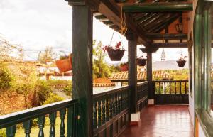 a porch of a house with potted plants on it at Cabaña la Cattleya de Villa de Leyva in Villa de Leyva