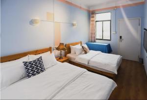 a bedroom with two beds and a window at Changsha Fuxiangyuan International Hostel in Changsha