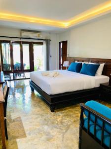a bedroom with a large bed with blue pillows at Baan Yaimai Boutique Samui in Bophut