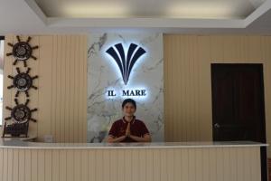 a man standing behind a counter in a room with a sign at Lanta IL Mare Beach Resort in Ko Lanta