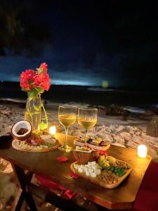 uma mesa com copos de vinho e comida na praia em Pousada Paraíso das Tartarugas em Pipa