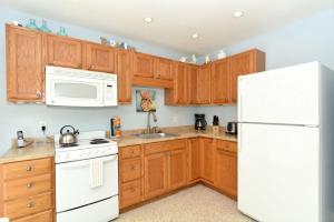 a kitchen with wooden cabinets and a white refrigerator at Minnow 2 Villa in Anna Maria