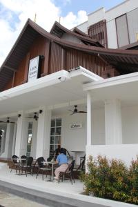 a person sitting at a table outside of a building at Luckswan Boutique Chiang Rai - SHA Extra Plus in Chiang Rai