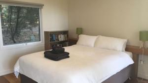 a black bag sitting on a bed in a bedroom at Mt Singapore Villas - Villa 2 in Yanakie