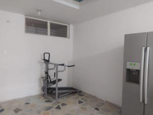 a room with a treadmill next to a refrigerator at Apartamento Villa Rocio in Yopal