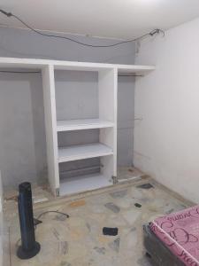 a room with a white book shelf in a room at Apartamento Villa Rocio in Yopal