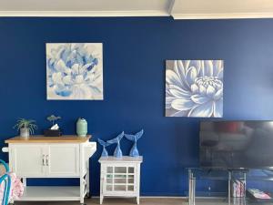 Marina Views Apartment Cullen Bay في Larrakeyah: غرفة بها لوحتين على جدار أزرق
