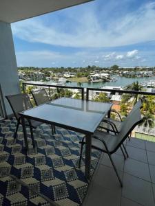 uma mesa e cadeiras numa varanda com vista para a água em Marina Views Apartment Cullen Bay em Larrakeyah