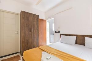 um quarto com uma cama e uma cabeceira em madeira em StayhomeStays Prime em Bangalore