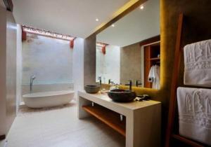 y baño con bañera, lavamanos y bañera. en Anema Wellness Villa & Spa Gili Lombok - Diving Center PADI en Tanjung