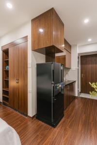 a kitchen with a black refrigerator and wooden cabinets at Ann's Home in Hanoi