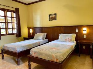 two beds in a room with yellow walls at Tipolo Beach Resort in Moalboal