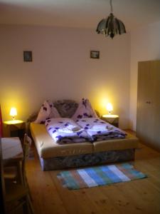a bedroom with a bed and two lights on the wall at Chalupa Tourov in Bavorov