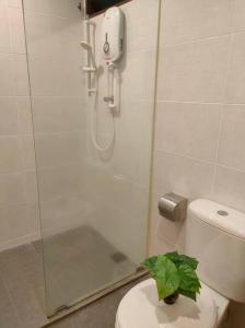 La salle de bains est pourvue d'une douche et de toilettes avec une plante. dans l'établissement PG56 Gurney Gleneagles Landed, à George Town