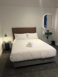 1 dormitorio con 1 cama con 2 toallas en Sportsmens Club Hotel, en Wagga Wagga