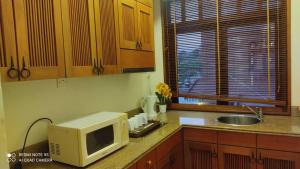 a kitchen with a microwave and a sink at the sunset view lagoon suite in Pantai Cenang