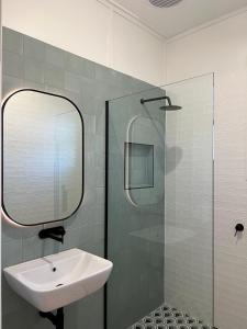 a bathroom with a sink and a glass shower at Sportsmens Club Hotel in Wagga Wagga