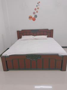 a bed with a wooden headboard and some buttons on the wall at Narayan nivas homestay in Ujjain