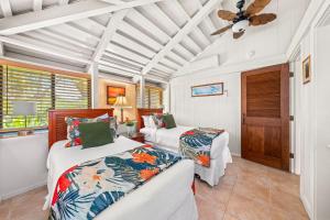 a bedroom with two beds and a ceiling fan at International Colony Club 34 in Lahaina