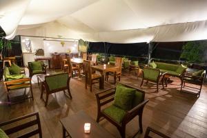 un ristorante con tavoli e sedie e una tenda di Bellway Chalets a Dedugala