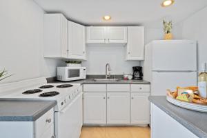 a kitchen with white cabinets and a white refrigerator at Hale Ono Loa 214 in Kahana