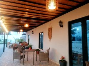 a patio with a wooden ceiling and a table and chairs at Hotel Sol de Ocucaje in Ica