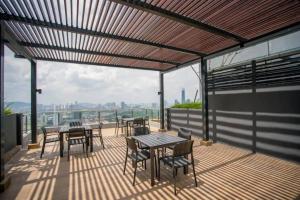 un patio con tavoli, sedie e vista sulla città di 2 Bedroom Cozy Suite with Attached Bathrooms a Kuala Lumpur