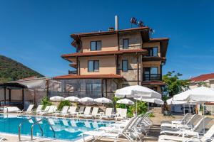 a hotel with a pool and chairs and a building at Saint George Mountain Residence in Belashtitsa
