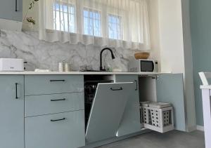 cocina blanca con fregadero y encimera en Casa Marzi, en Terracina