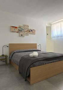 1 dormitorio con 1 cama grande con marco de madera en Casa Marzi, en Terracina