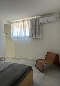 1 dormitorio con 1 cama, 1 silla y 1 ventana en Casa Marzi, en Terracina