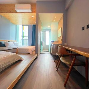 une chambre d'hôtel avec deux lits et un bureau dans l'établissement Anpingzen chaiju, à Tainan