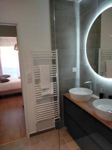 uma casa de banho com 2 lavatórios e um espelho em Gîte des Gônes - Lyon Charme em Feyzin