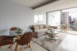 a living room with a couch and a table at Stunning Harbour Bridge and Opera House Views! in Sydney