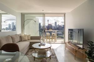 a living room with a couch and a view of a city at Stunning Harbour Bridge and Opera House Views! in Sydney