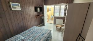 a bedroom with a bed and a tv on the wall at Résidence Fleur des Pins - Gites & Chambres d'Hôtes in Saint-Georges-dʼOléron