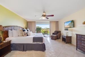 a bedroom with a bed and a ceiling fan at Eldorado K103 in Kahana