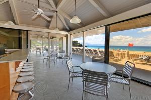 a dining room with tables and chairs and the beach at Eldorado J218 in Kahana
